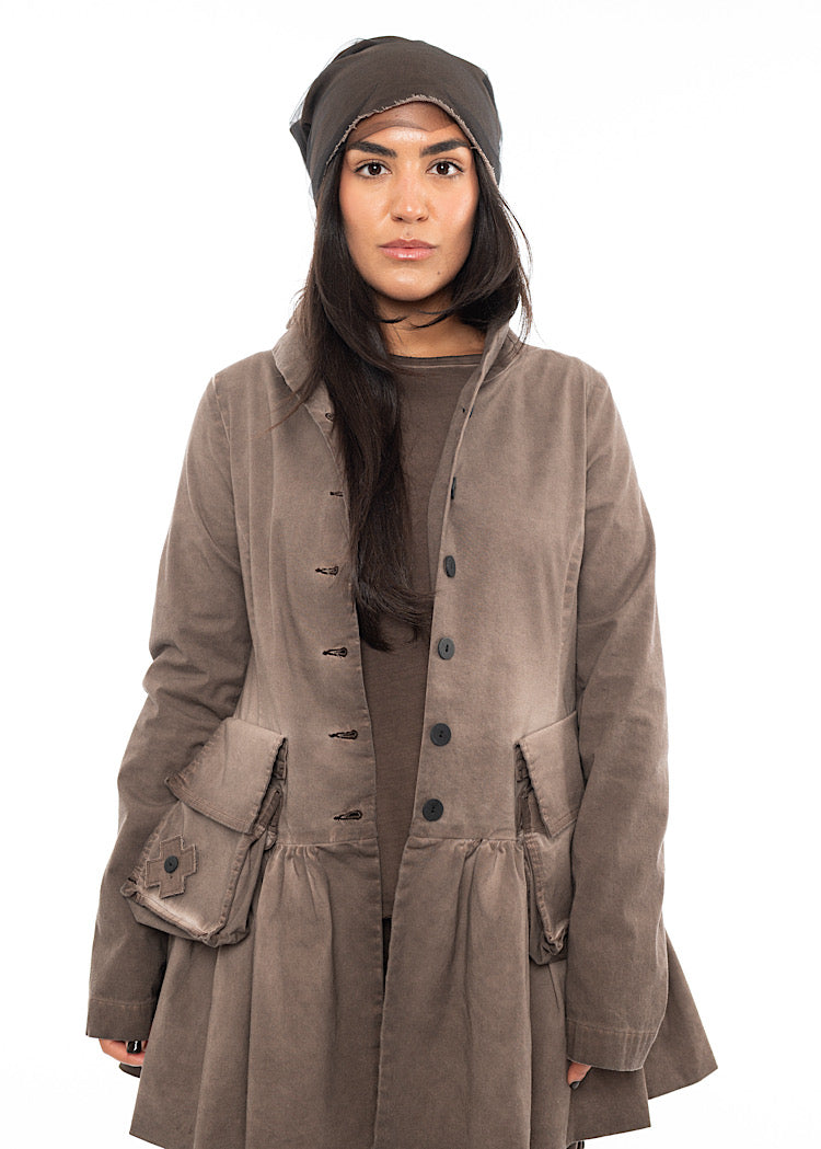 A Model wearing a matching Chocolate Brown outfit including an oversized jacket, an A-line top and straight skirt. Featuring a mesh beanie.