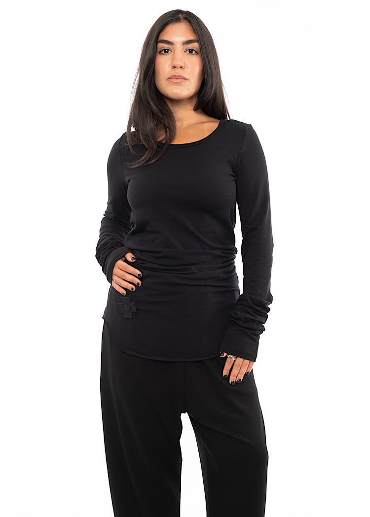 A Model wearing a long sleeved top, with a cross patch to the left of the top.Styled with matching trouser.