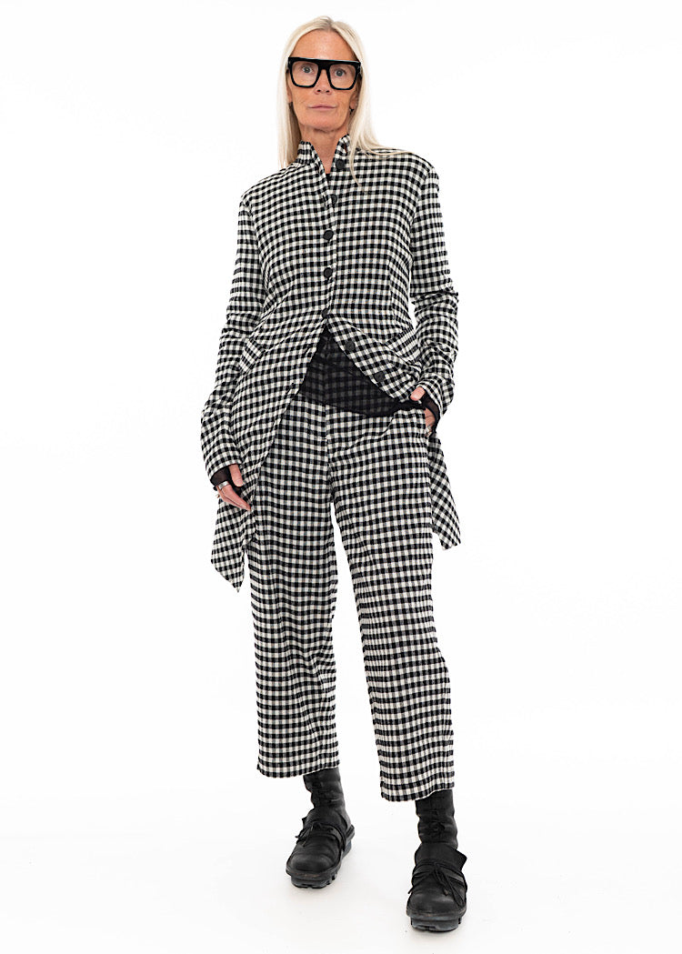 Model wearing a coordinated black and white gingham check shirt and wide-leg trousers set, styled with black mesh top and black combat boots