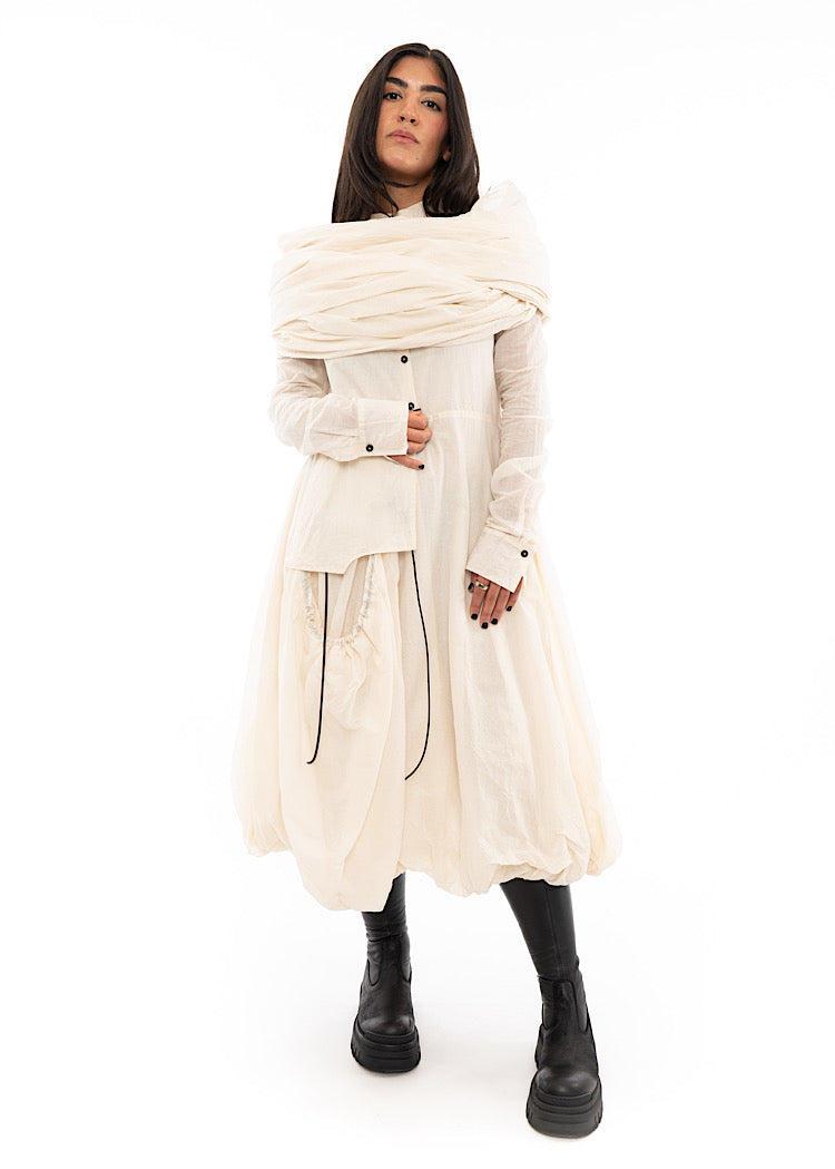 A full frame photo of A Model wearing an oversized Scarf wrapped around her shoulders .Showing the different styles to approach.