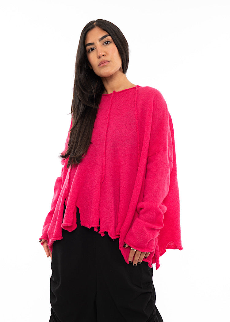 A Model wearing a Bright Pink oversized Pullover. Showing the ruching effect on the sleeves.