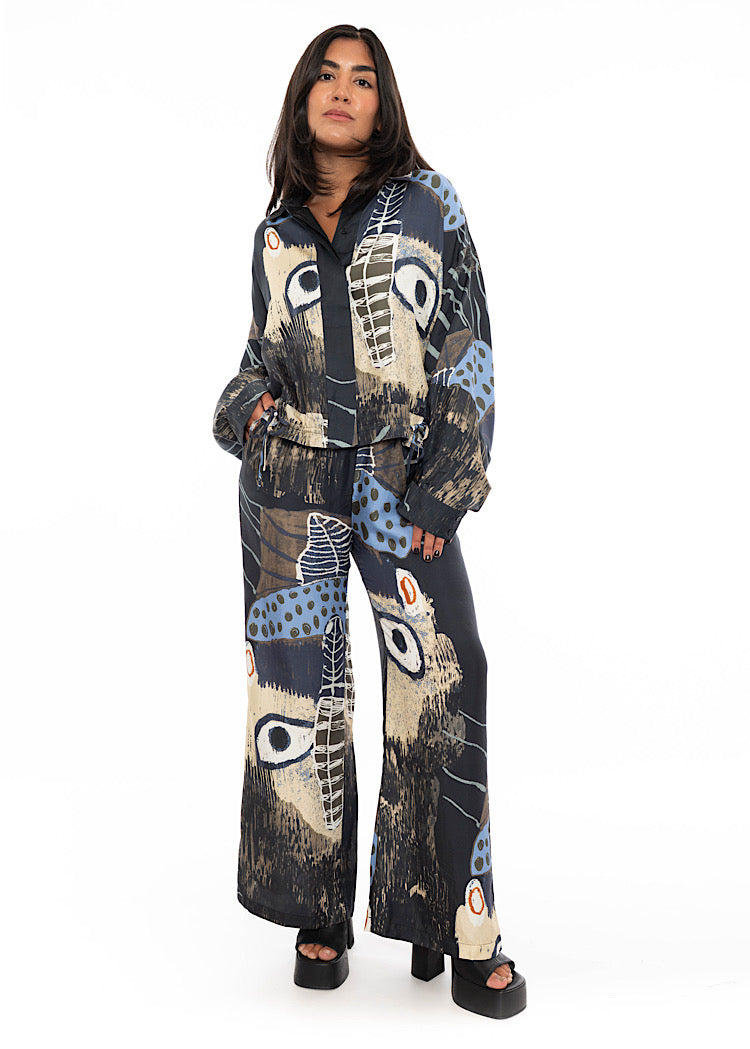 A model wearing a wide leg Silk trouser with a matching shirt. Standing facing the front disclosing the full outfit look.