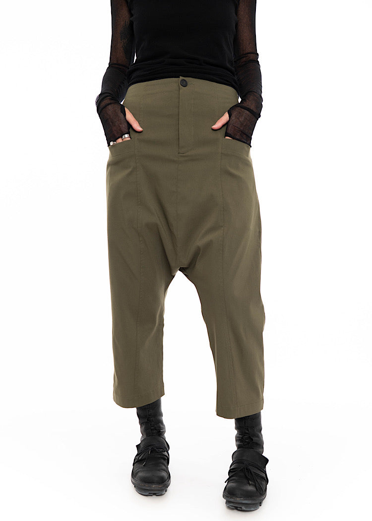 Model wearing Olive Green Drop-Crotch trouser with front pockets in a cropped style. Styled with long sleeve mesh black top and combat boots.
