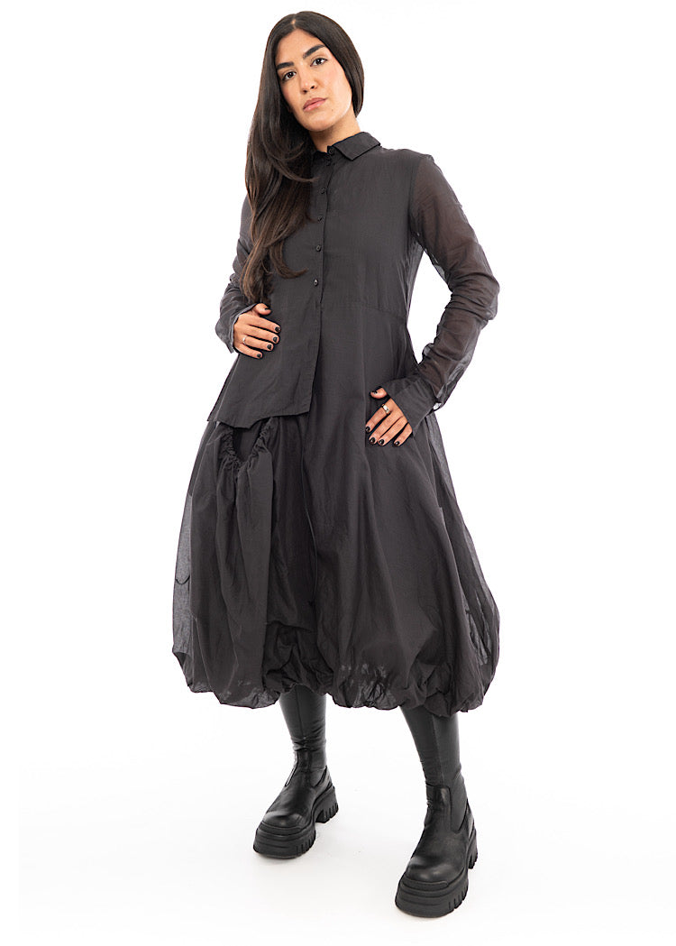 A full frame photo of A Model wearing a bubble skirted Dress in a washed Grey colour. Focusing on the size of the quilted Skirt.