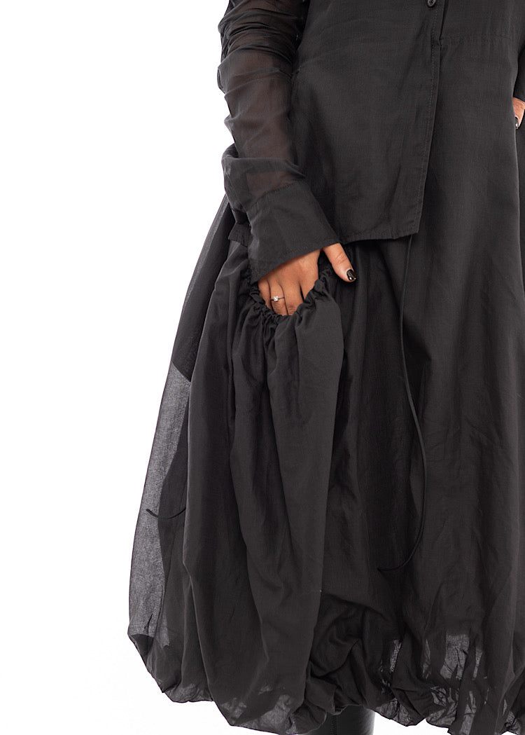 An up close off A Model wearing a bubble skirted Dress in a washed Grey colour. Focusing on the pocket area of the Skirt.