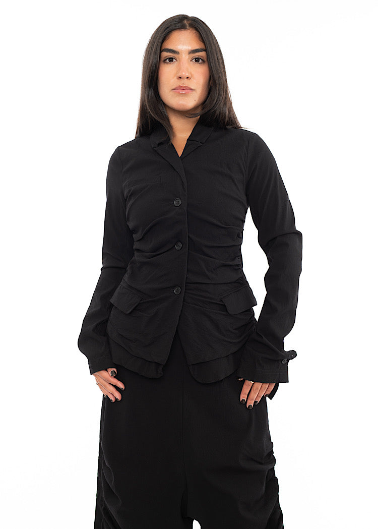 A Model wearing a minimalist techno Jacket and matching trousers, in a Black colour.