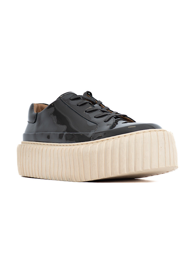 A picture of a washed Grey glossy patent leather Shoe. Showing the beige platform sole which adds height finished with a classic lace up.