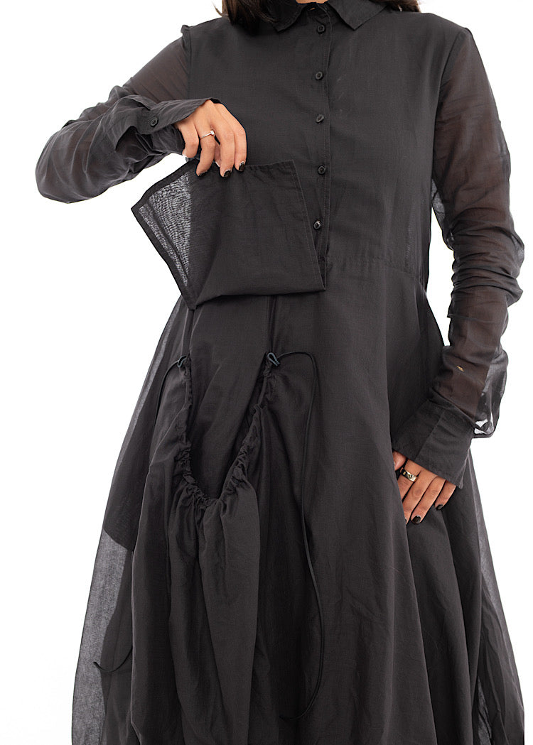 An up close off A Model wearing a bubble skirted Dress in a washed Grey colour. Focusing on the pocket/ pocket flap of the Skirt.