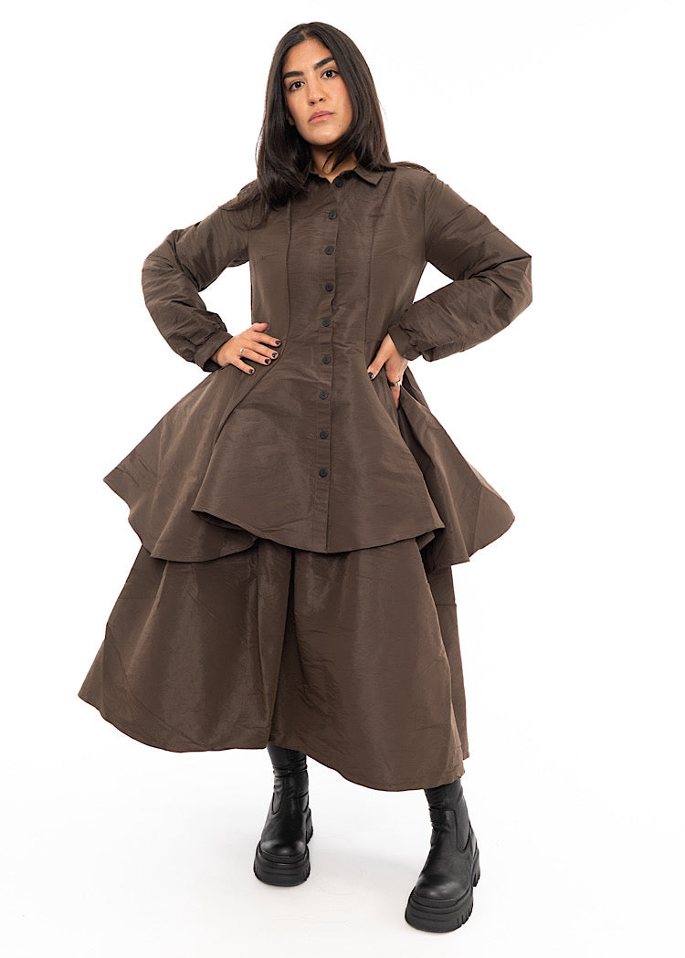 A Model wearing a Chocolate Brown structured Shirt.Featuring a collared neckline, buttons to fasten and balloon sleeves. Styled with a structured matching skirt.