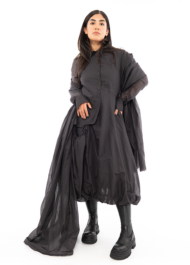 A full frame photo of A Model wearing a washed Grey Scarf which is wrapped around her shoulders. Styled with a matching long-sleeved bubble dress.