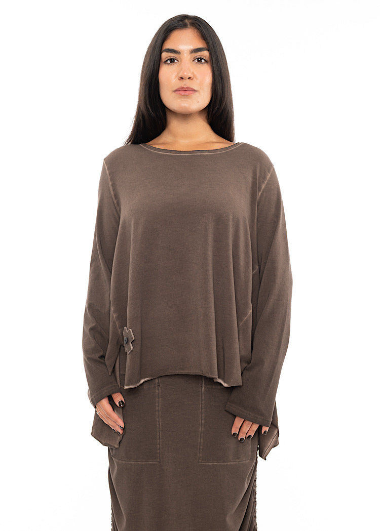 A Model wearing a Chocolate Brown Pullover with a scoop neckline, long sleeves and an asymmetric hemline. Styled with a matching Chocolate Brown Skirt.