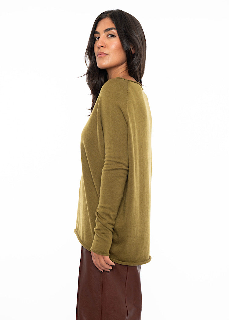 A Model standing to the side wearing a relaxed fit khaki green pullover with a slash neckline and long sleeves. Showing the length of the arms.