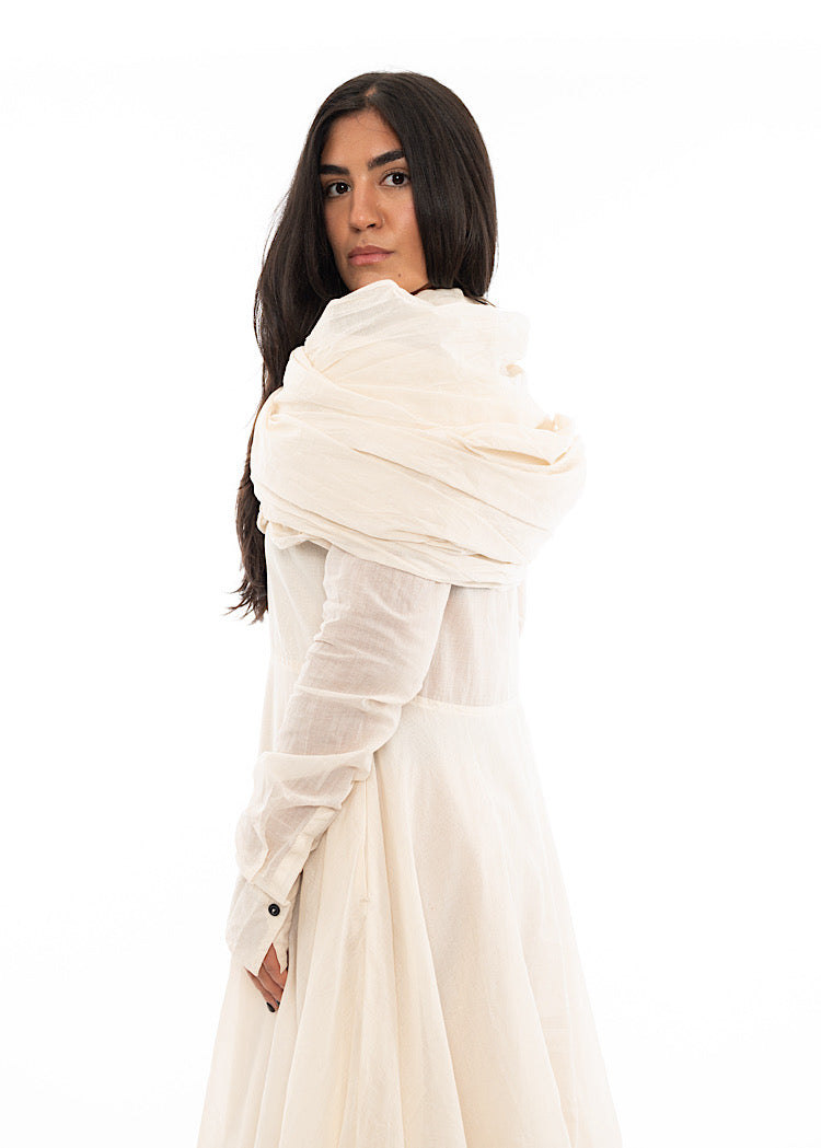 A Model wearing an oversized Scarf wrapped around her shoulders adding volume to the matching Dress.Showing the different styles to approach.