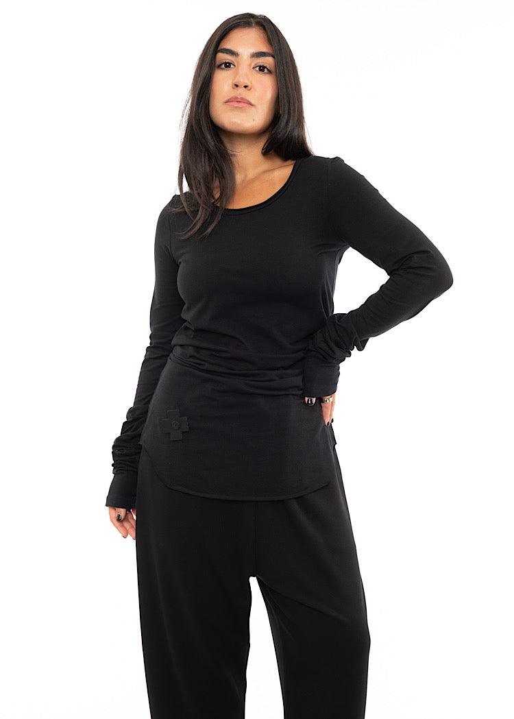 A Model wearing a long sleeved top, with a cross patch to the left of the top.Styled with matching trouser.