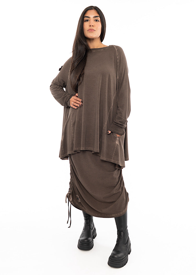A Model wearing a Chocolate Brown oversized top with distressed dyed seam detailing and a slash neckline. Styled with a matching drawstring skirt and Black Chunky Boots.