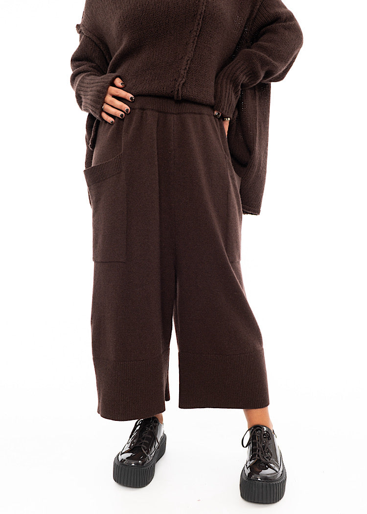 A Model wearing a Brown Knitted Skirt with pockets. Showing the waistband of the piece in more detail.