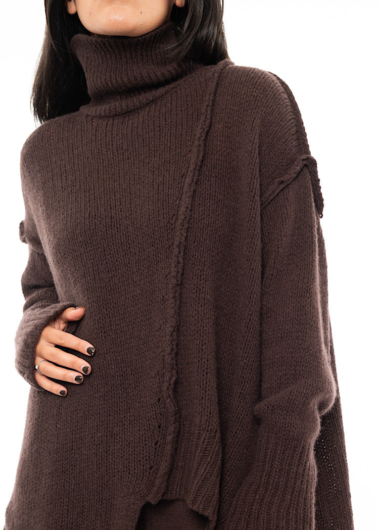 An up close off A Model wearing a Brown Oversized pullover. Showing the pieces material and structure in more detail.