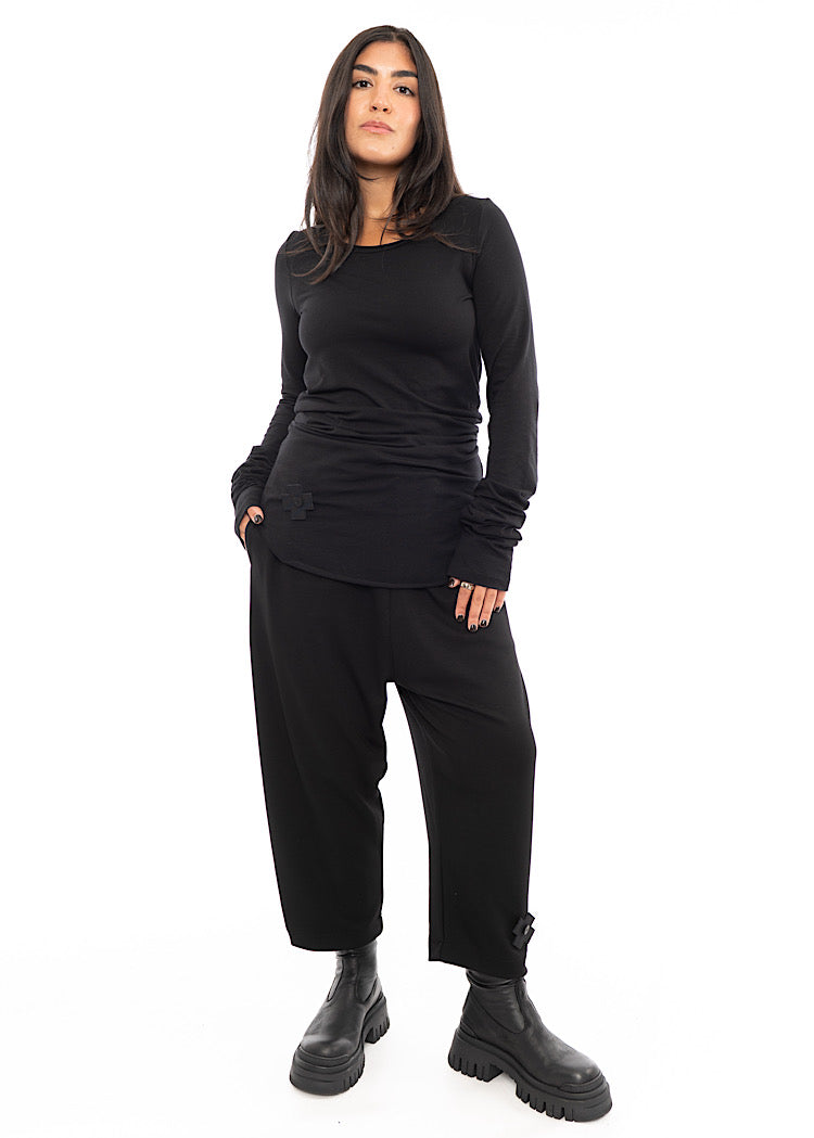 A Model wearing a long sleeved top, with extra material around waist and sleeves which creates a rouging effect. Styled with matching trouser and Black Chunky Boot.
