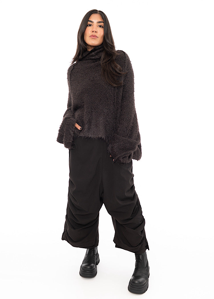A full size photo of A Model wearing a Chocolate Fluffy pullover. Paired with matching trousers and a Black Boot.