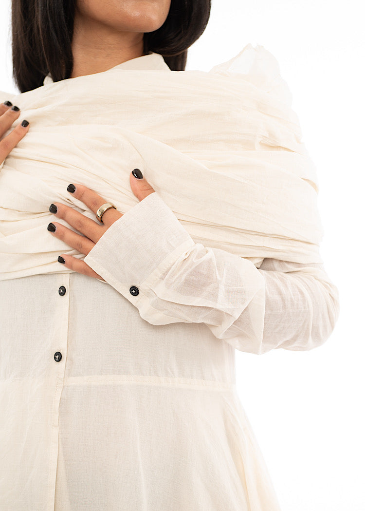 An up close photo of A Model wearing an oversized Scarf wrapped around her shoulders .Showing the material in more detail.