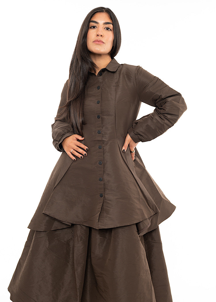 A Model wearing a Chocolate Brown structured Shirt.Featuring a collared neckline, buttons to fasten and balloon sleeves. Styled with a balloon structured matching skirt.