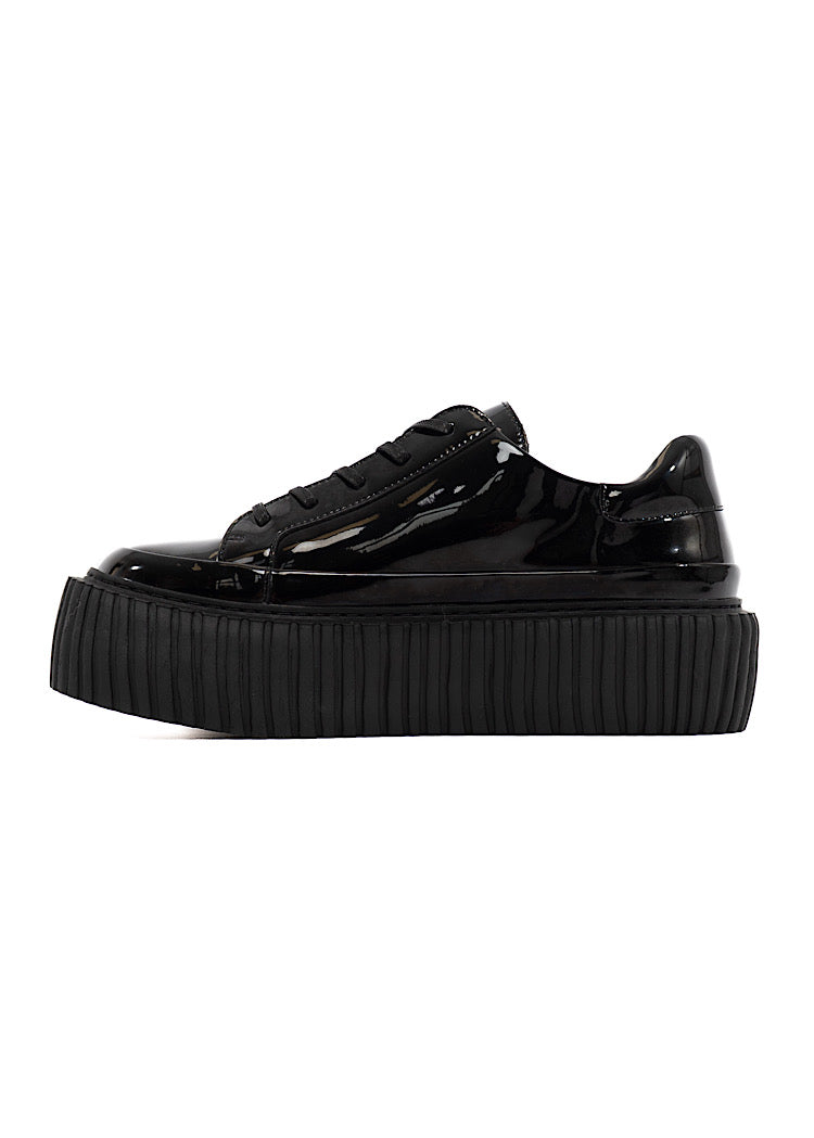 A picture of a Black glossy patent leather Shoe. Showing the matching Chunky Sole which adds height. Finishing with a classic lace up detail.